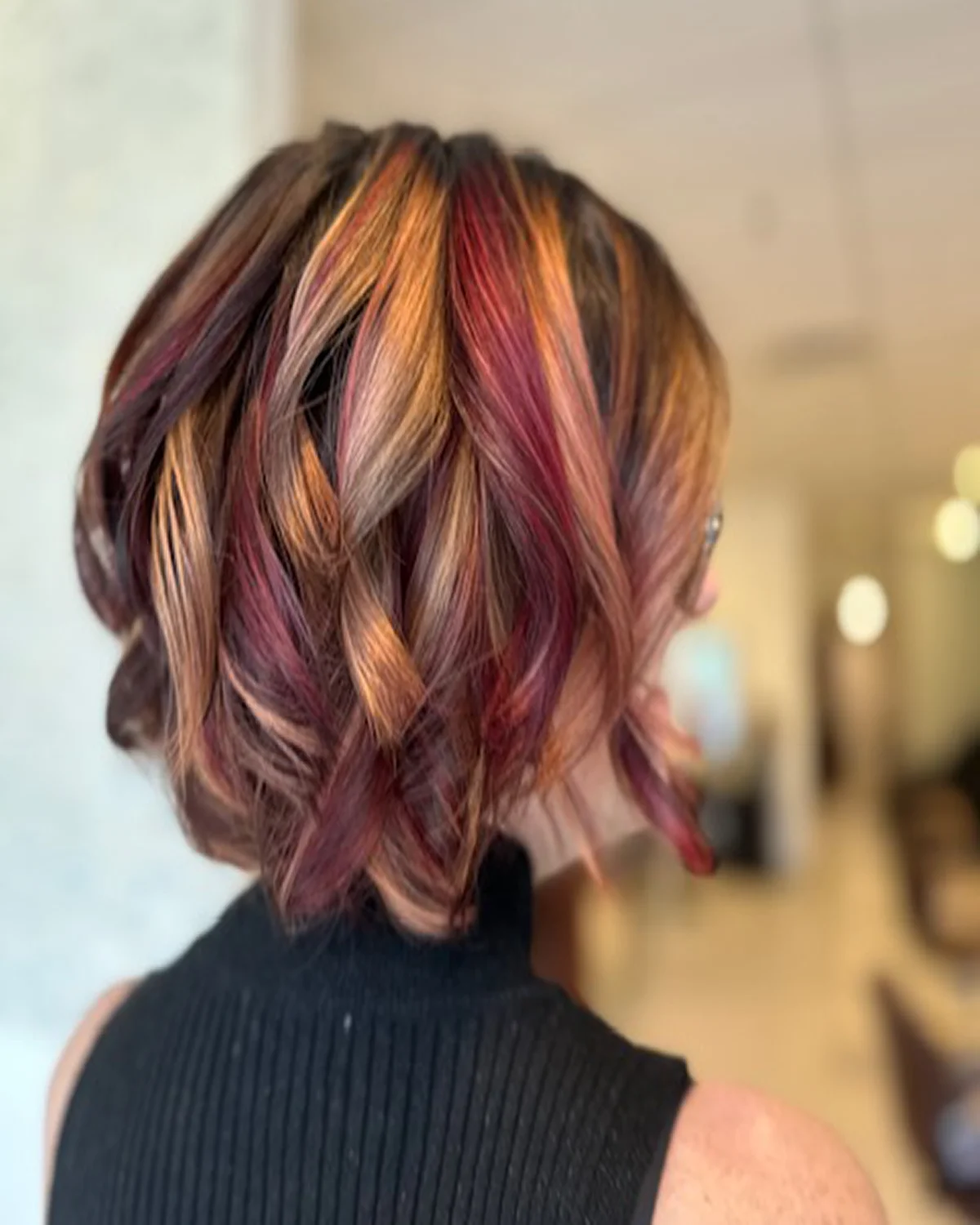 Copper magenta fashion hair color with dimensional ribbons, soft movement, and radiant shine at Box Office Hair in Winter Springs, Florida.