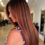 Signature copper hair color featuring dimensional highlights, rich warmth, healthy length, and luminous shine.