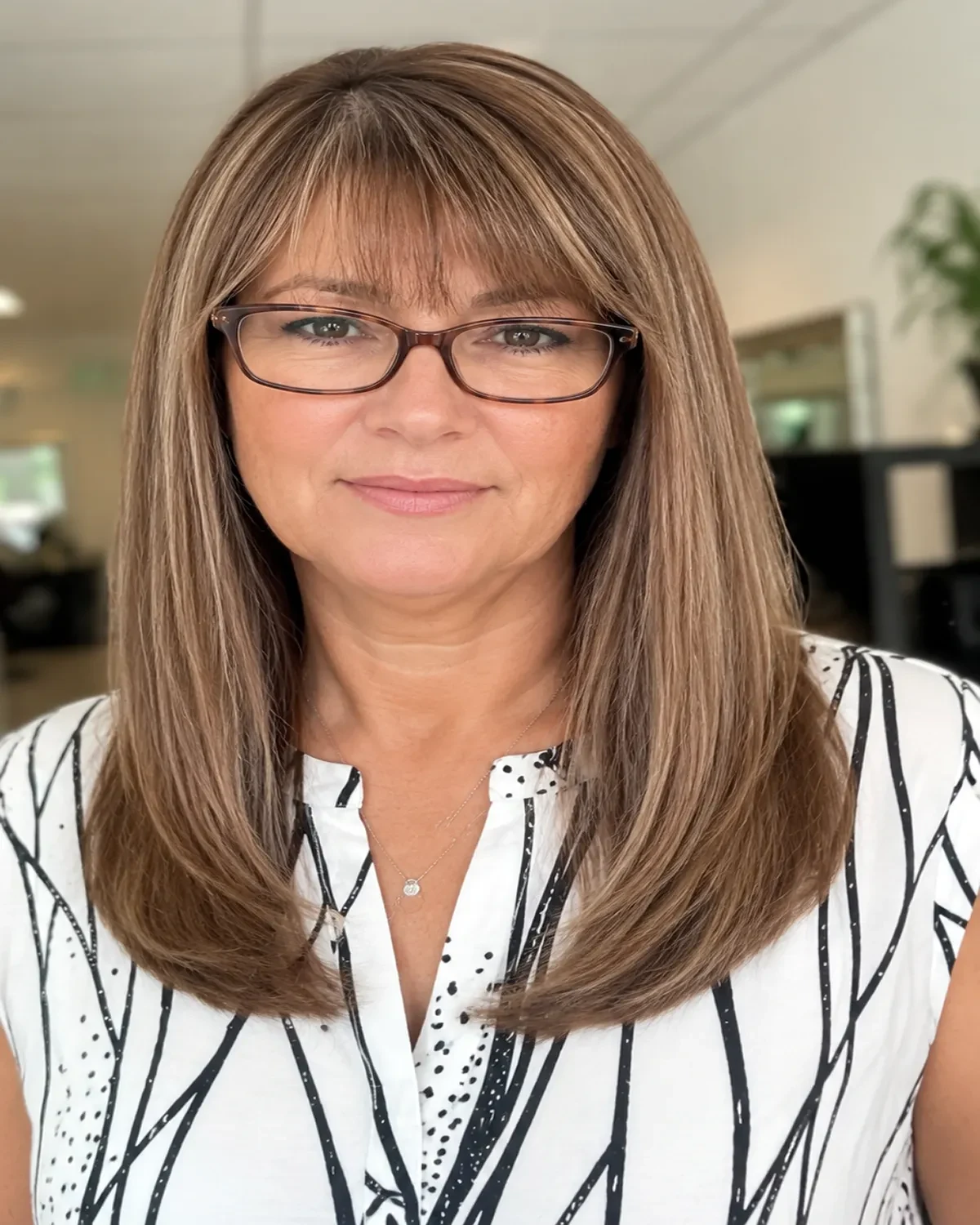 Shoulder-length dimensional brunette hair with soft face-framing highlights.